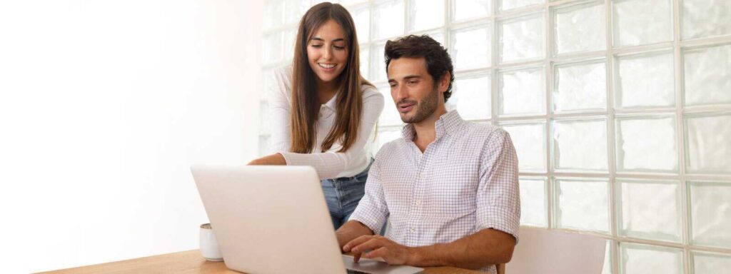 Hombre y mujer viendo algo en un computador 
